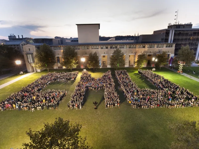People on the cut forming the letters CMU