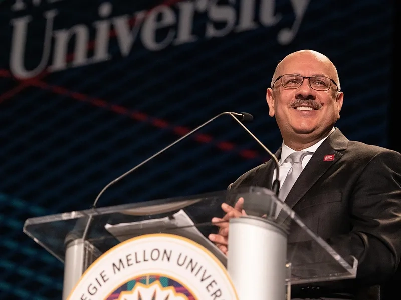 President Farnam Jahanian smiling at a podium