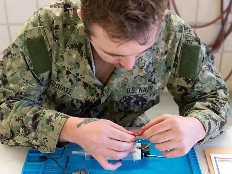 Navy soldier learning AI tools in CMU's Robotics Academy.