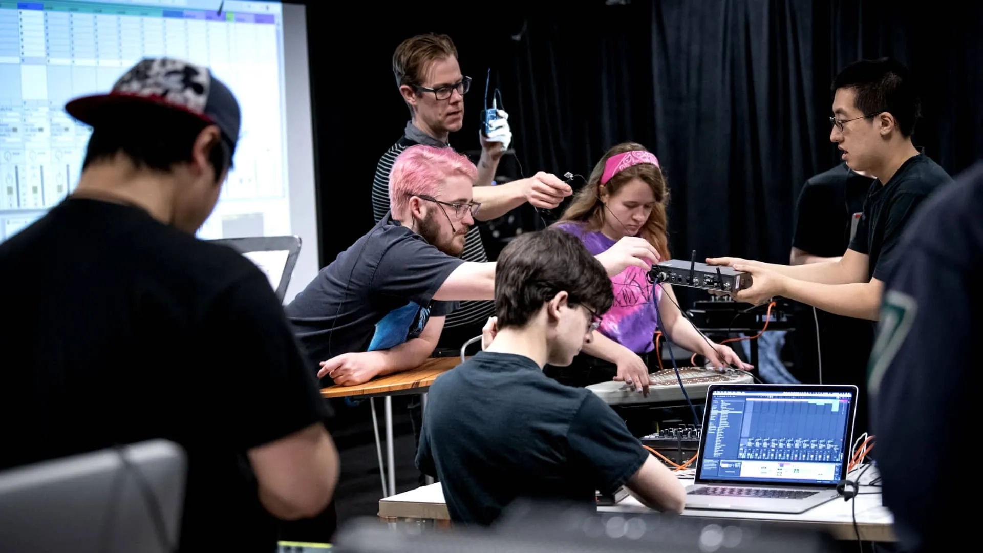 Group of CMU students in a hands-on workshop collaborating on an audio project using technical equipment and software