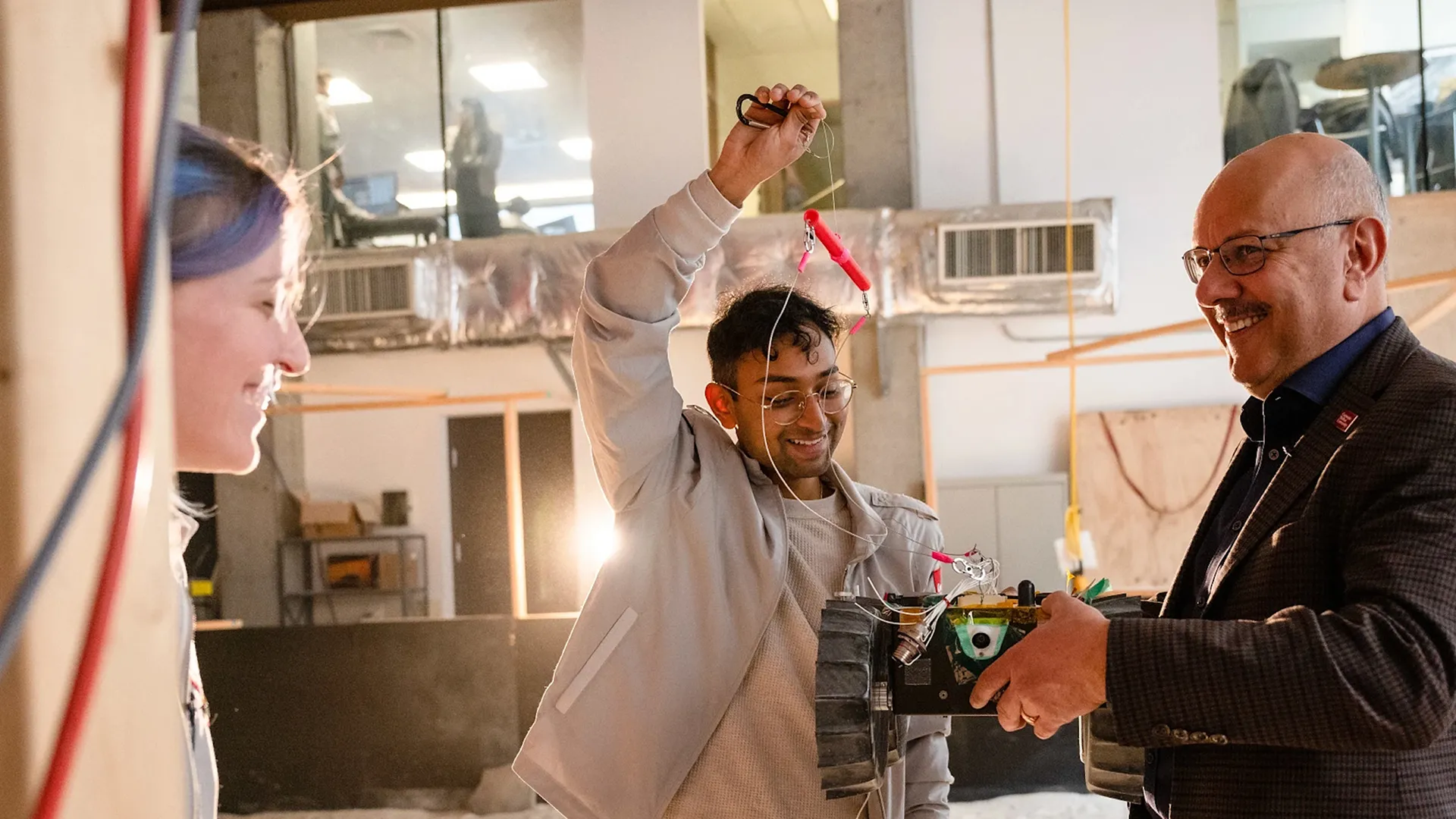 President Farnam Jahanian speaking with two students. 