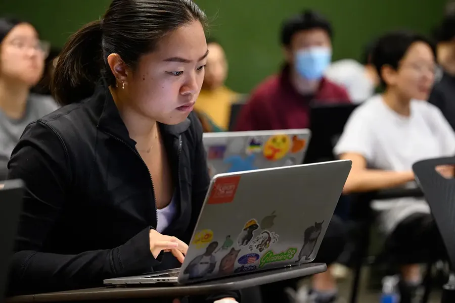 A CMU student working on a laptop.